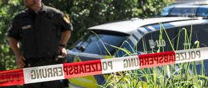 01.07.2025, Bayern, Mellrichstadt: Ein Polizist steht neben einem Polizeiauto.