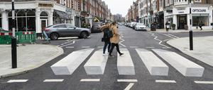 Zwei Fußgängerinnen gehen über den ersten 3D-Zebrastreifen Großbritanniens in St. Johns Wood.