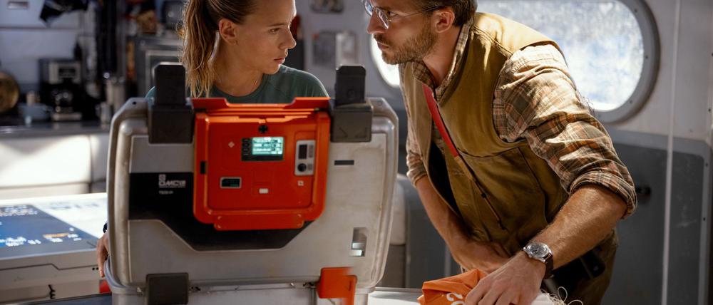 Scarlett Johansson (l) als Zora Bennett und Jonathan Bailey als Dr. Henry Loomis in einer Szene des Films „Jurassic World: Die Wiedergeburt“.