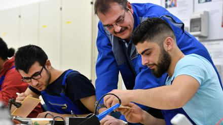 Die Geflüchteten Muhsen Armandezi (r.) aus Syrien und Basel Khudeda Majoun (l.) aus dem Irak bei der Arbeit in Deutschland (Archivbild).