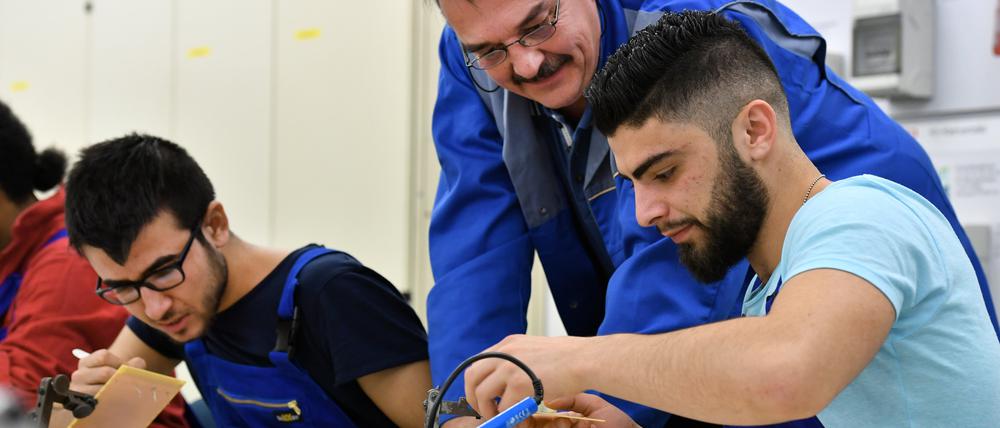 Die Geflüchteten Muhsen Armandezi (r.) aus Syrien und Basel Khudeda Majoun (l.) aus dem Irak bei der Arbeit in Deutschland (Archivbild).