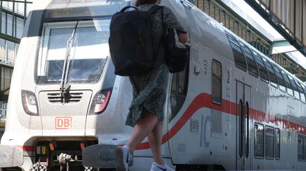 Stuttgart: Eine Frau geht auf einem Bahnsteig im Hauptbahnhof zu einem IC Zug der Deutschen Bahn.
