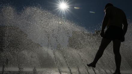 ARCHIV - 24.06.2025, Bayern, München: Ein Mann kühlt sich an einem Brunnen im Wasser ab. (zu dpa: «Wetterdienst misst bislang höchste Temperatur des Jahres») Foto: Peter Kneffel/dpa +++ dpa-Bildfunk +++