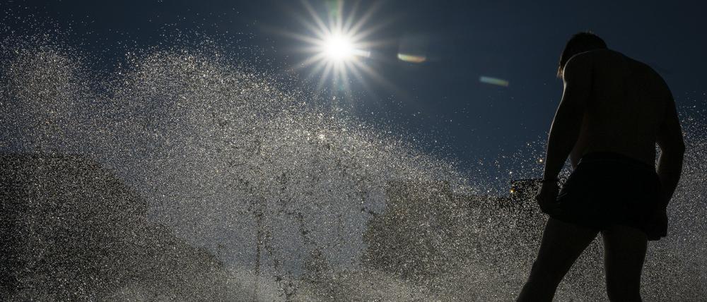 ARCHIV - 24.06.2025, Bayern, München: Ein Mann kühlt sich an einem Brunnen im Wasser ab. (zu dpa: «Wetterdienst misst bislang höchste Temperatur des Jahres») Foto: Peter Kneffel/dpa +++ dpa-Bildfunk +++