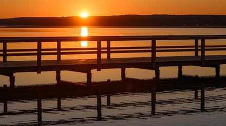 Brandenburg, Wendisch Rietz: Der Sonnenaufgang leuchtet am frühen Morgen über dem Scharmützelsee.