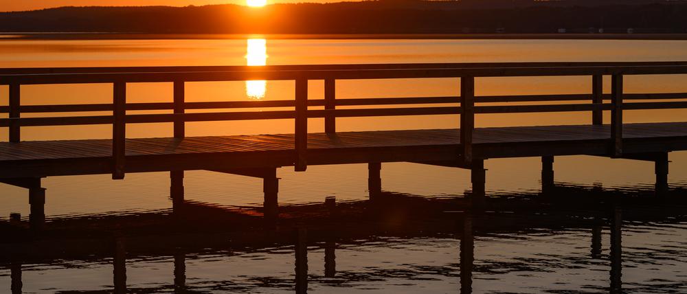 Brandenburg, Wendisch Rietz: Der Sonnenaufgang leuchtet am frühen Morgen über dem Scharmützelsee.