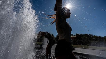 Temperaturen von annähernd 40 Grad in der Hauptstadt - diese Touristen nutzen einen Brunnen zur Abkühlung.