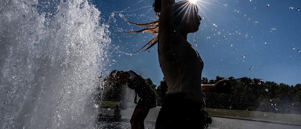 Temperaturen von annähernd 40 Grad in der Hauptstadt - diese Touristen nutzen einen Brunnen zur Abkühlung.