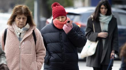 Warm angezogene Menschen gehen durch die Argentiniens Hauptstadt Buenos Aires. 