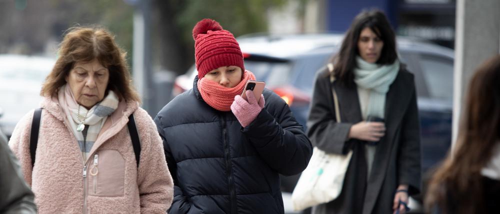 Warm angezogene Menschen gehen durch die Argentiniens Hauptstadt Buenos Aires.