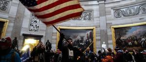 Eine Person schwenkt die US-Flagge im Inneren des US-Kapitols, nachdem Anhänger des damaligen US-Präsidenten Trump das Gebäude gestürmt hatten (Symbolbild).