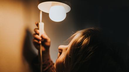 Ein Mädchen betätigt den Schalter einer Lampe (Symbolbild).