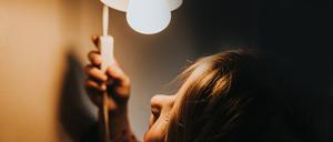 Ein Mädchen betätigt den Schalter einer Lampe (Symbolbild).