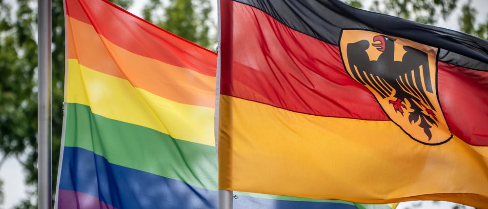 Eine Regenbogenflagge weht neben der Deutschlandfahne vor dem Bundesverteidiungsministerium.
