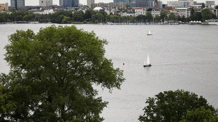 Zwei Segelboote sind auf der Außenalster unterwegs. 
