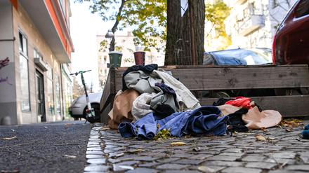 Weggeworfene Kleidung liegt in Neukölln auf dem Gehweg am Straßenrand. 