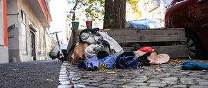 Weggeworfene Kleidung liegt in Neukölln auf dem Gehweg am Straßenrand. 