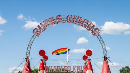 04.07.2025, Nordrhein-Westfalen, Bielefeld: Der Hochseilartist David Ruiz vom Zirkus Charles Knie balanciert auf einem Seil über dem Zirkuszelt, wo eine Regenbogenfahne aus Protest hängt. Der Zirkus will aus Protest gegen die Haltung von Bundeskanzler Merz und Bundestagspräsidentin Klöckner (beide CDU) die Regenbogenfahne auf dem Zirkuszelt hissen. (zu dpa: «Zirkus hisst Regenbogenfahne aus Protest gegen Merz») Foto: Guido Kirchner/dpa +++ dpa-Bildfunk +++