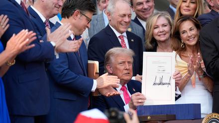 Trump präsentiert stolz seine Unterschrift unter das Gesetz. 