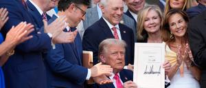 Trump präsentiert stolz seine Unterschrift unter das Gesetz. 