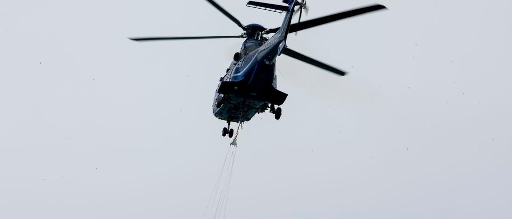 Ein Löschhubschrauber der Bundespolizei fliegt über dem Zeithainer Tagebau und nimmt Wasser auf, um den Waldbrand Gohrischheide zu bekämpfen.