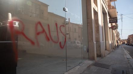 Ein Graffiti mit der Aufschrift „Raus“ ist am Fenster eines Immobilienbüros in Santanyi auf Mallorca zu sehen.