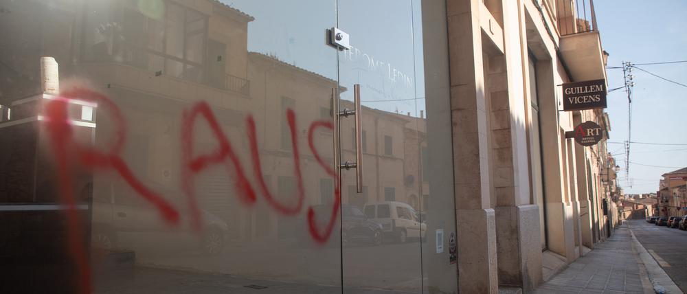 Ein Graffiti mit der Aufschrift „Raus“ ist am Fenster eines Immobilienbüros in Santanyi auf Mallorca zu sehen.