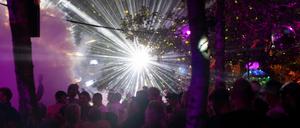  Das Festival Nation of Gondwana: Menschen tanzen unter Bäumen, bunte Lichter leuchten in der Dunkelheit.