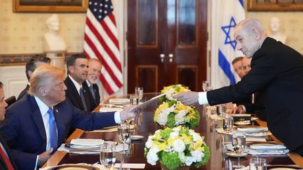 Benjamin Netanjahu (r), Ministerpräsident von Israel, überreicht US-Präsident Donald Trump eine Mappe während eines Treffens im Blue Room des Weißen Hauses in Washington. 