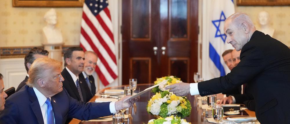 Benjamin Netanjahu (r), Ministerpräsident von Israel, überreicht US-Präsident Donald Trump eine Mappe während eines Treffens im Blue Room des Weißen Hauses in Washington. 
