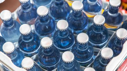 Symbolbild: Zu sehen ist eine Kiste mit Mineralwasser in Glasflaschen mit Kronenkorken.