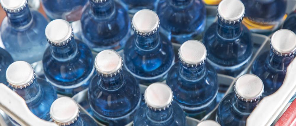 Symbolbild: Zu sehen ist eine Kiste mit Mineralwasser in Glasflaschen mit Kronenkorken.