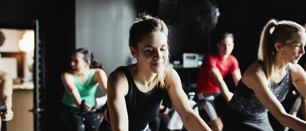 Eine Fitnessklasse auf stehenden Fahrrädern im Studio..