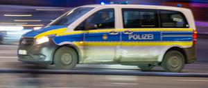 Ein Polizeiauto fährt mit Blaulicht zu einem Einsatz (Symbolbild).