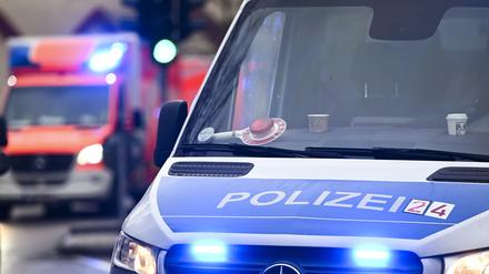 ARCHIV - 04.12.2024, Berlin: Ein Polizeiauto und ein Rettungswagen mit Blaulicht. (zu dpa: «25-Jähriger durch Stich in Kopf lebensgefährlich verletzt») Foto: Jens Kalaene/dpa +++ dpa-Bildfunk +++