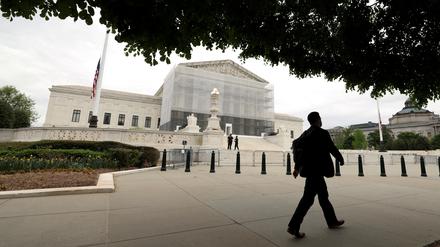 FILE PHOTO: A person walks past the U.S. Supreme Court in Washington, D.C., U.S., April 21, 2025. REUTERS/Kevin Lamarque/File Photo