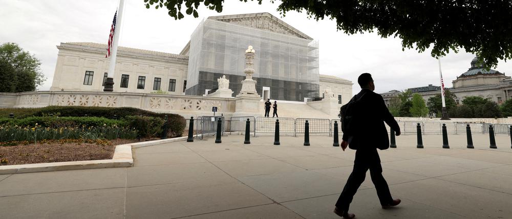 FILE PHOTO: A person walks past the U.S. Supreme Court in Washington, D.C., U.S., April 21, 2025. REUTERS/Kevin Lamarque/File Photo