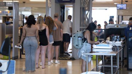 Menschen betreten eine Sicherheitskontrolle der Transportation Security Administration am internationalen Flughafen von Philadelphia. Die Schuhe dürfen an den Füßen bleiben.