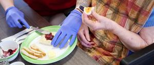 Eine Pflegekraft unterstützt eine Seniorin beim Frühstück im DRK-Pflegezentrum Solferino.