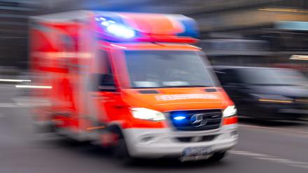 Ein Rettungswagen der Feuerwehr fährt mit Blaulicht zum Einsatz (Symbolbild)