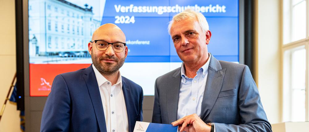 Brandenburg, Potsdam: René Wilke (parteilos, l), Innenminister von Brandenburg, und Axel Heidrich, kommissarischer Leiter der Verfassungsschutzabteilung, halten bei der Vorstellung den Verfassungsschutzbericht 2024 in der Hand. 