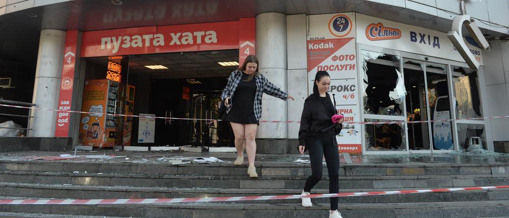 Zwei Frauen beim Verlassen eines Shoppingcenters, das bei einem russischen Angriff zerstört wurde.