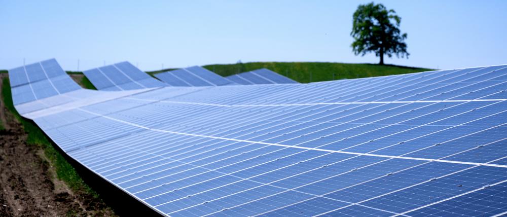 Die Sonne scheint auf einen Solarpark in der Nähe der Autobahn 95 (A95) auf einem Feld in Bayern.