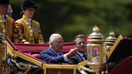 Der britische König Charles III. und Frankreichs Präsident Emmanuel Macron im Gespräch während der Kutschenprozession zum Schloss Windsor.  