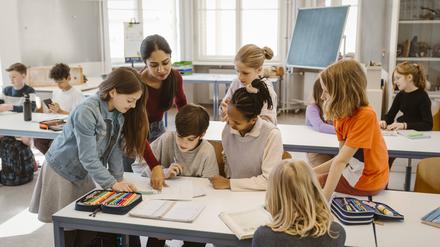 Female teacher assisting students learning together in classroom Germany, Berlin, model released, property released Copyright: xMaskotx , MA102342 MA102342