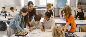 Female teacher assisting students learning together in classroom Germany, Berlin, model released, property released Copyright: xMaskotx , MA102342 MA102342