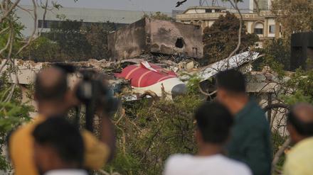 Menschen betrachten die Wrackteile abgestürzten Flugzeugs von Air India. 