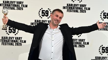 Der slowakische Regisseur Miro Remo posiert mit seiner Auszeichnung in der Hand. Miro gewann den Hauptpreis des 59. Karlsbader Filmfestivals.