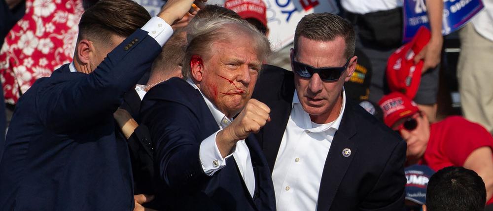 Das Bild zeigt Donald Trump kurz nach dem Anschlag auf der Bühne in Butler im US-Bundesstaat Pennsylvania am 13. Juli 2024.