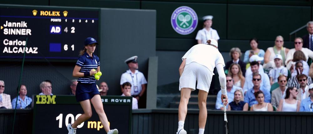 Was liegt denn da? Jannik Sinner hebt einen Champagnerkorken auf.